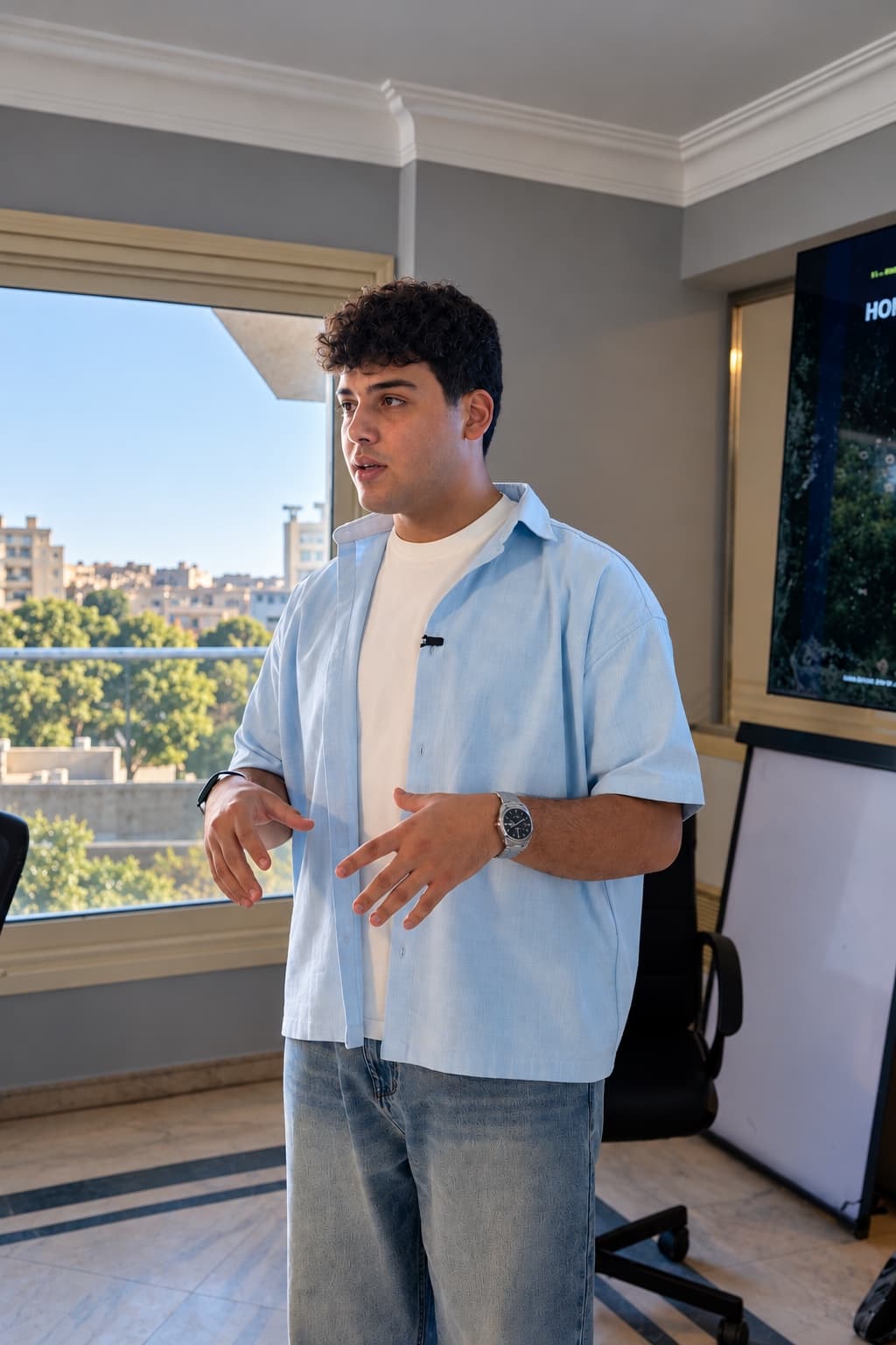 Anas Asfour speaking during a workshop, wearing a light blue shirt
