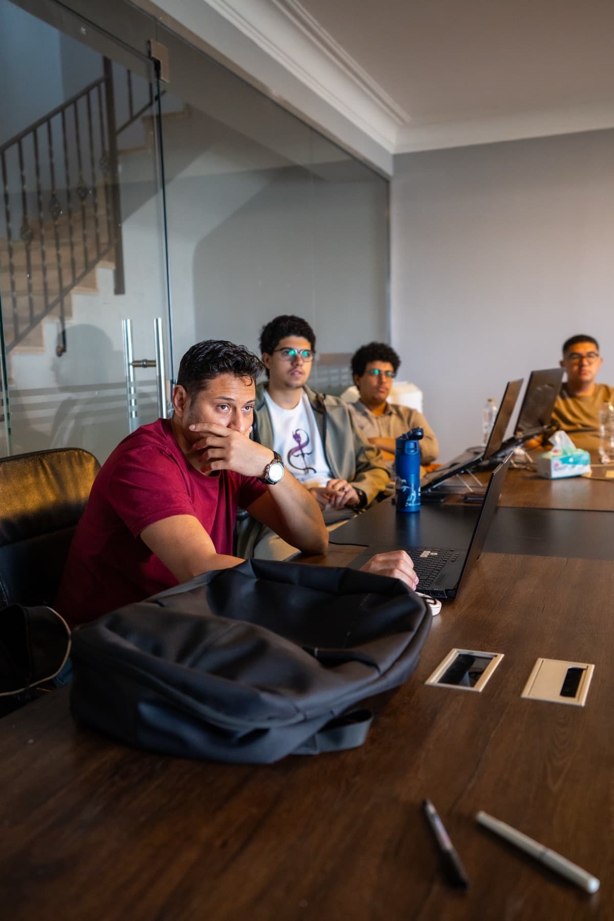 Workshop attendees listening, laptops open on the table